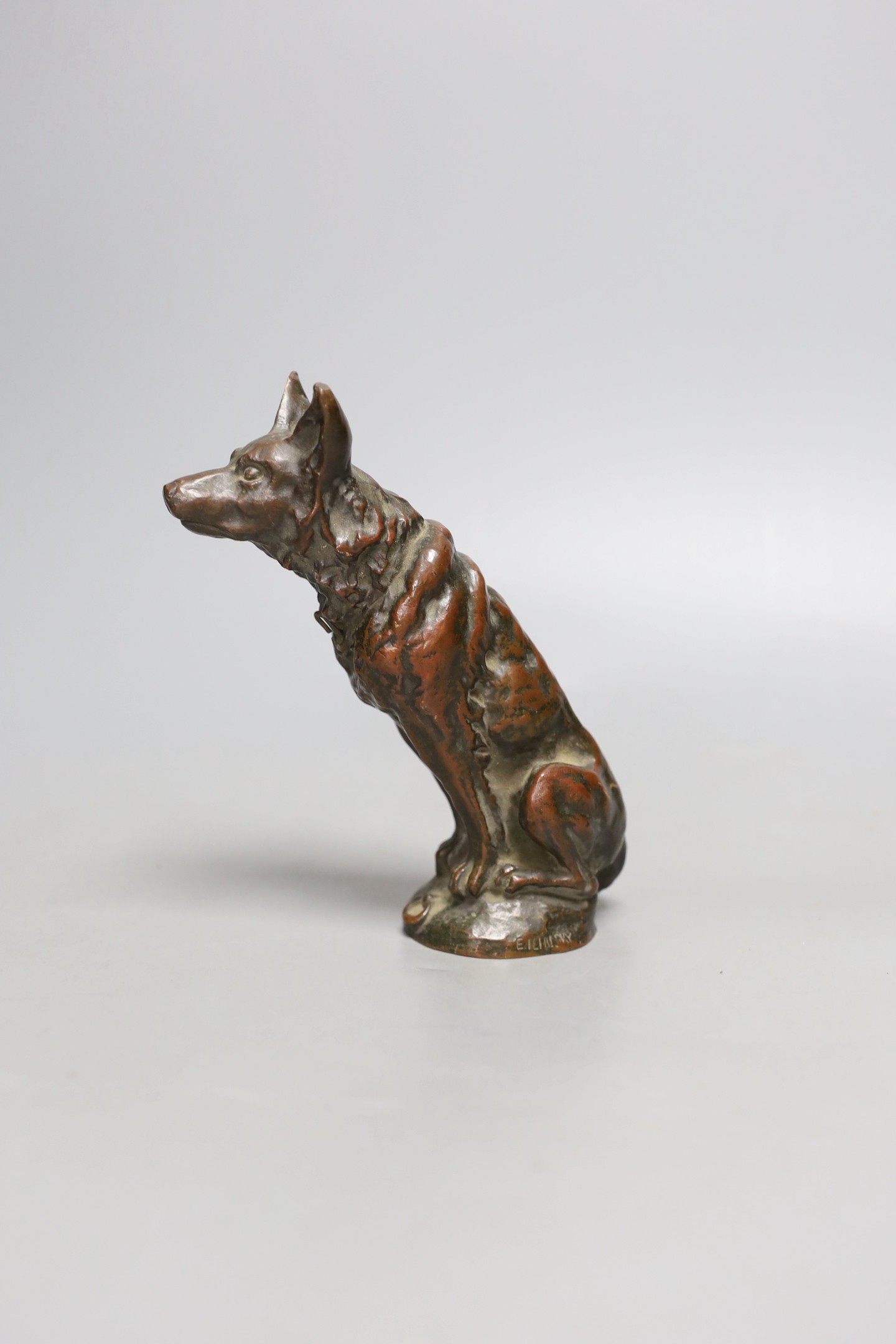 E, Ilinsky, a brown patinated bronze seated dog car mascot signed, worth foundry mark Fumiere et Cie, 16cm high